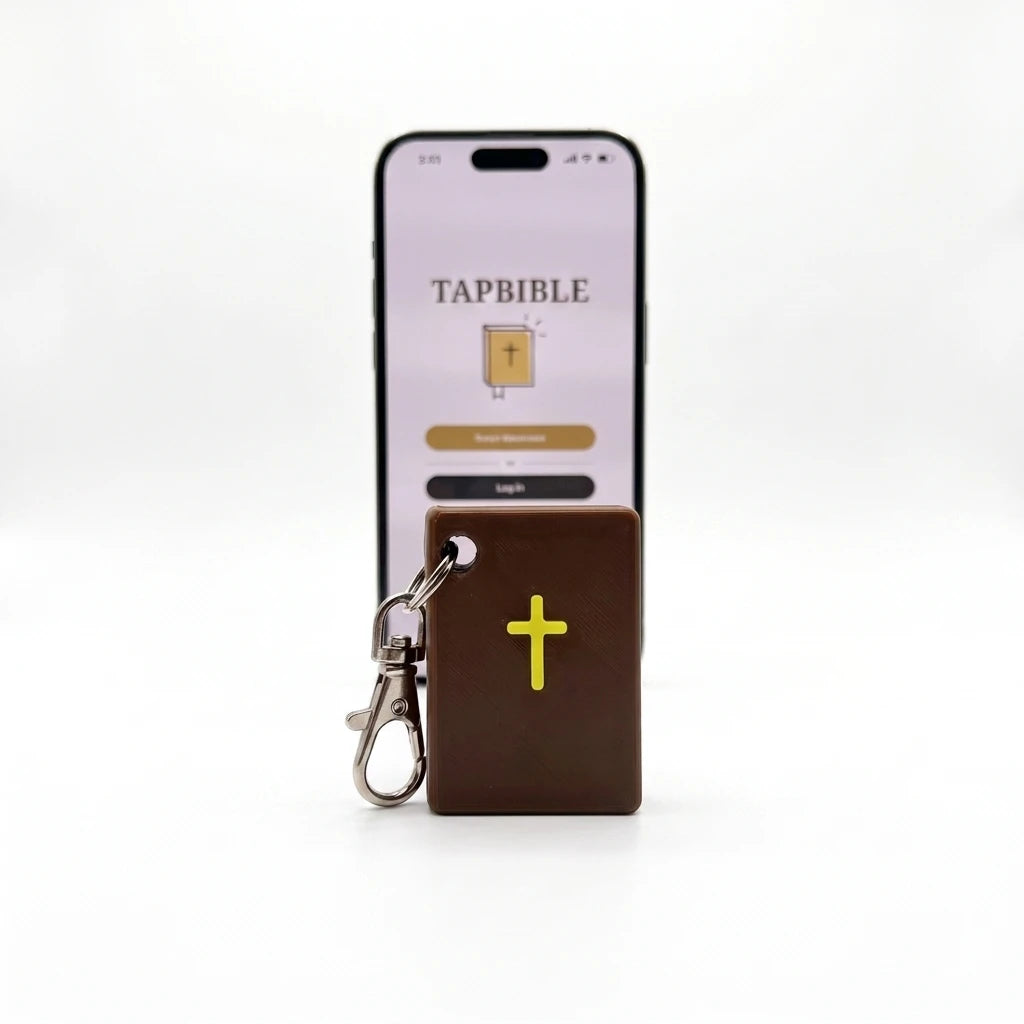 Brown TapBible Catholic NFC Bible keychain with a gold cross in front of a phone showing the TapBible app